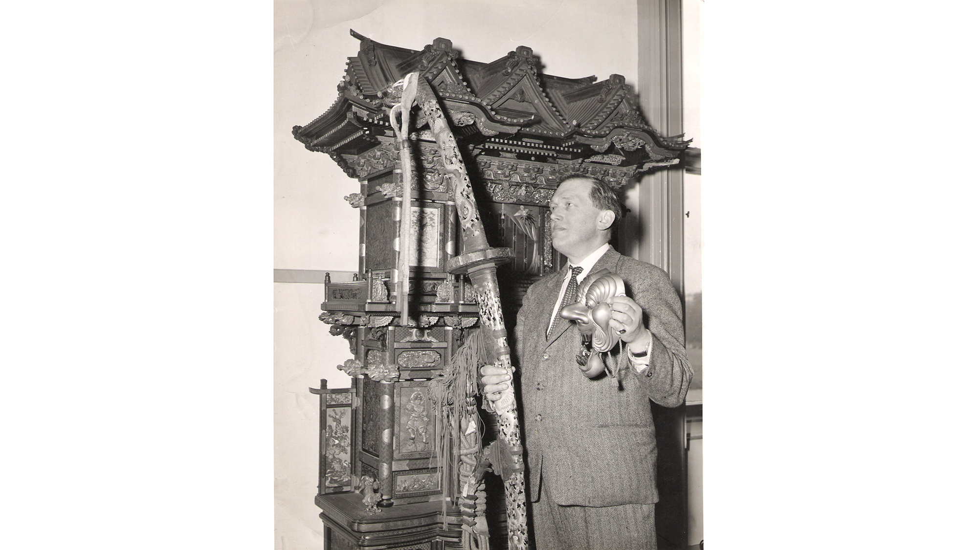 Man standing with sword and other Japanese objects