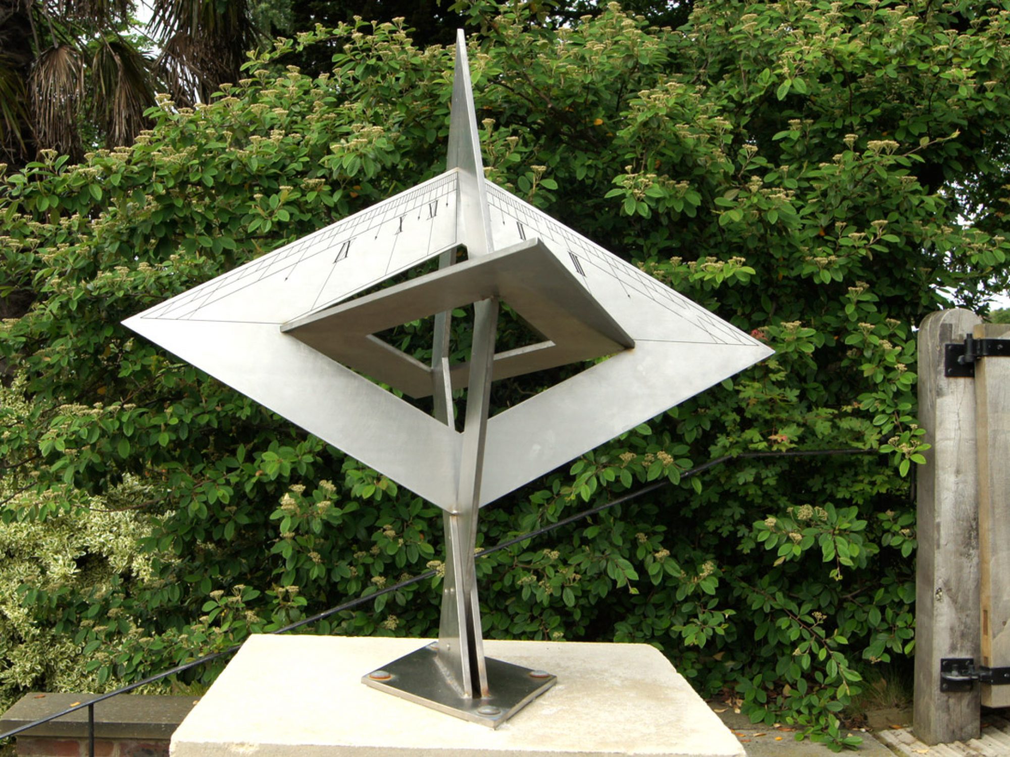A metal angular sundial in a garden