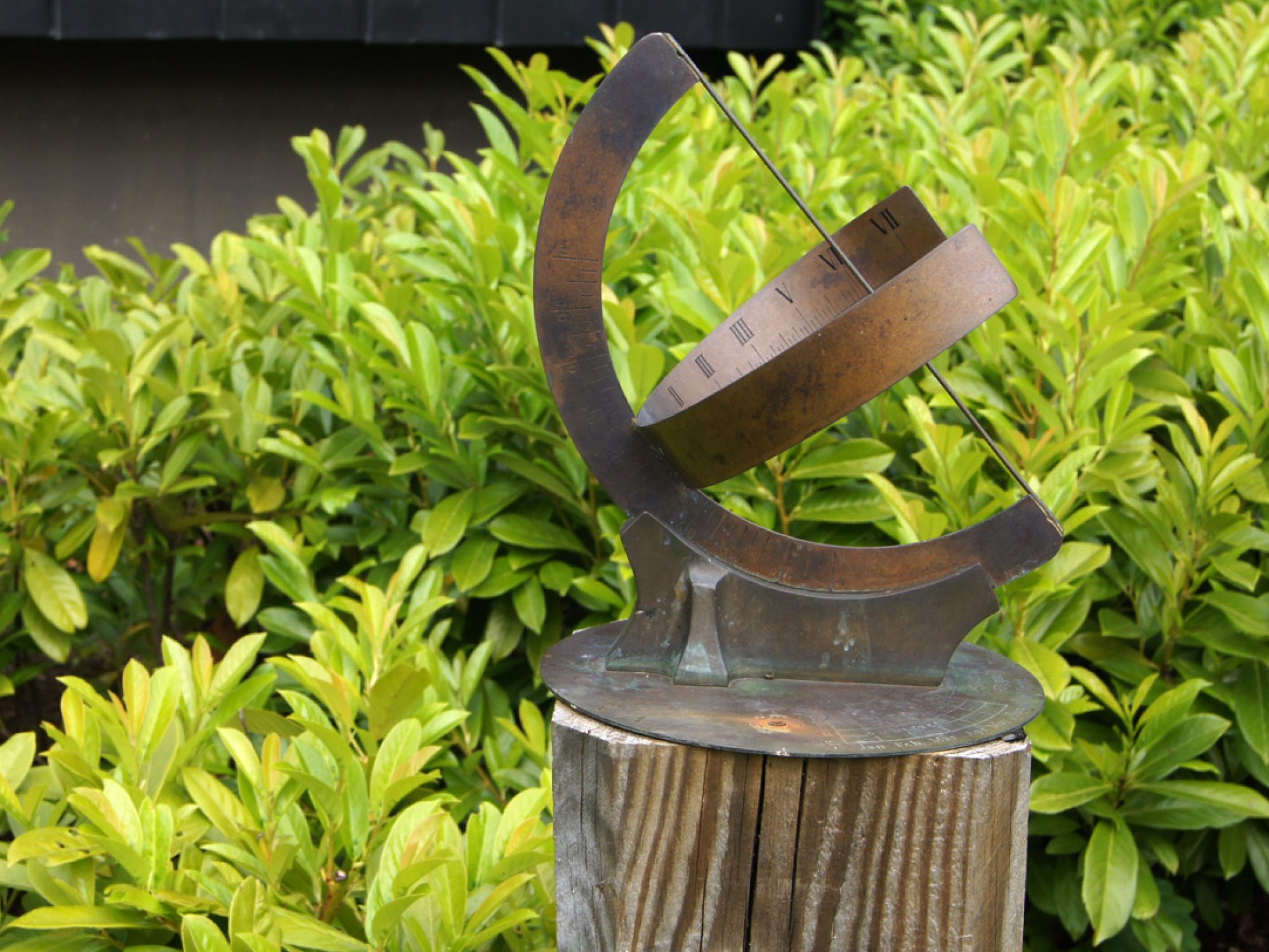 A metal curved sundial in a garden
