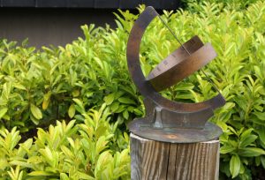 A metal curved sundial in a garden