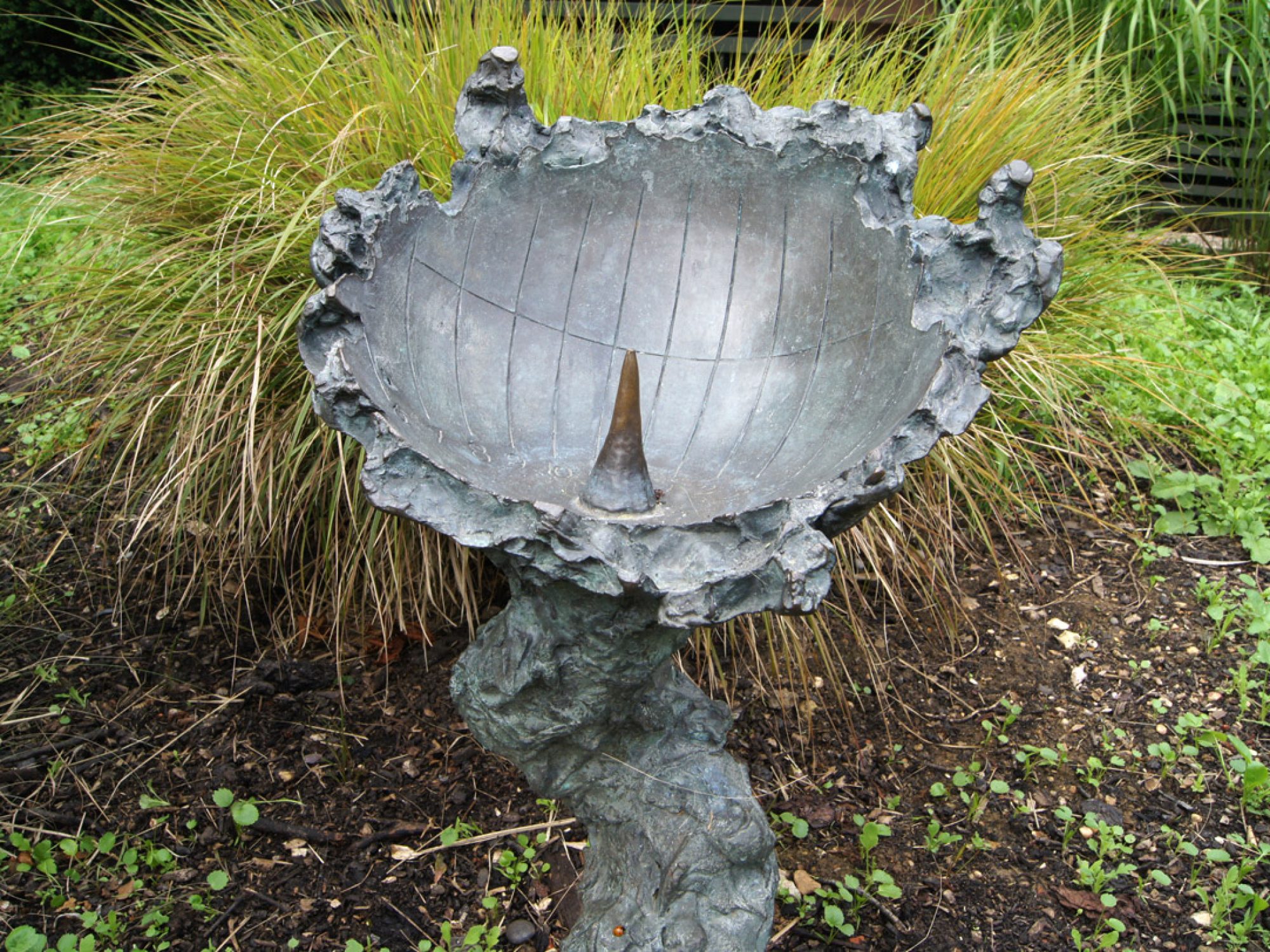 A sculptural bowl in a garden, acting as a sundial
