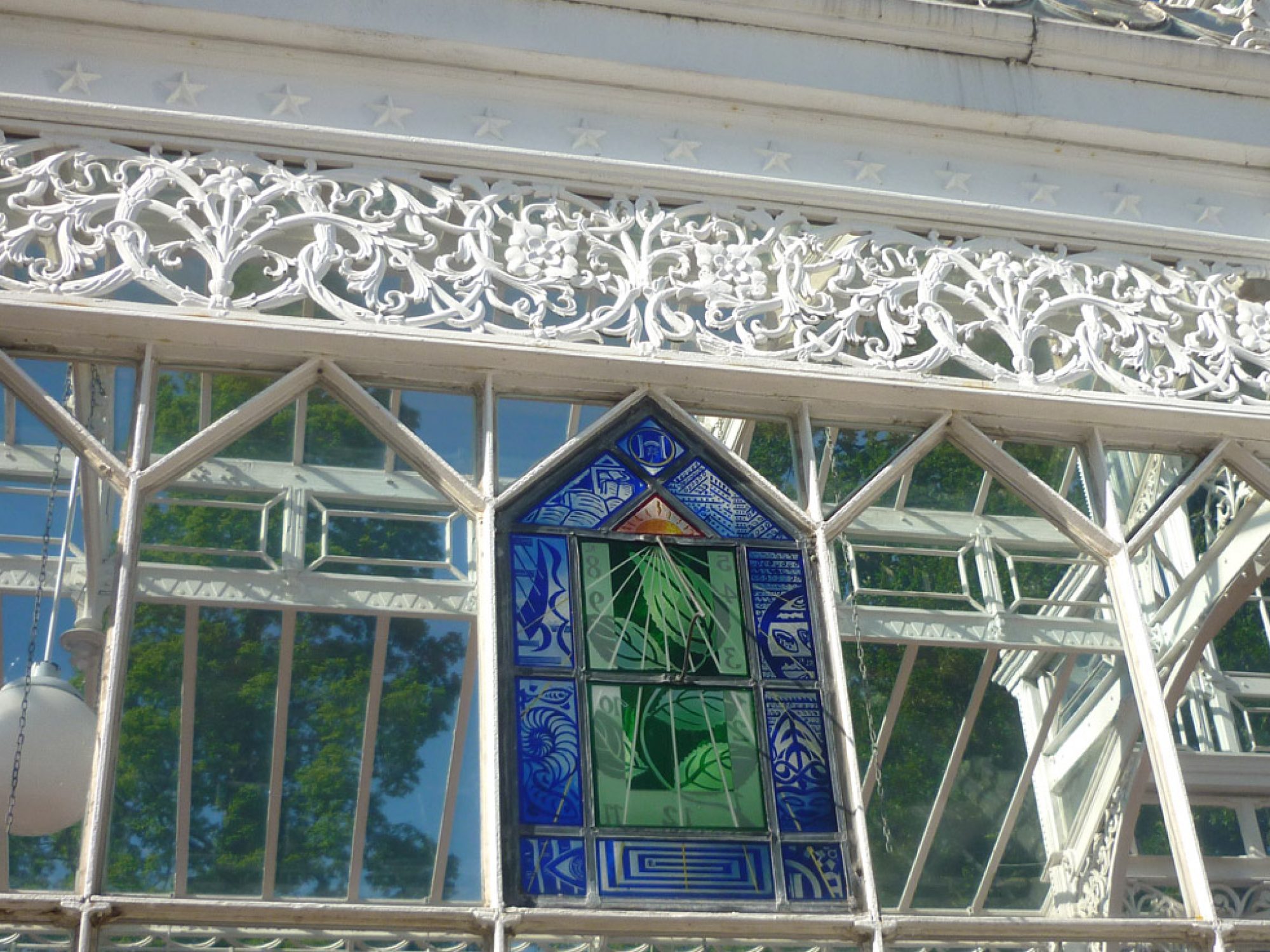 A glass panel in a conservatory with a sundial on it