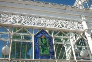 A glass panel in a conservatory with a sundial on it