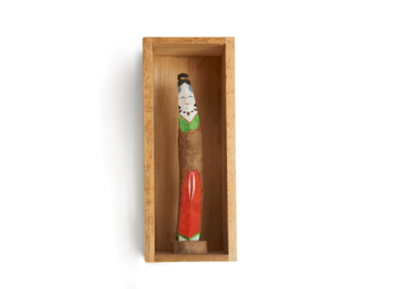 Long doll made from stick in a wooden box on a white background.