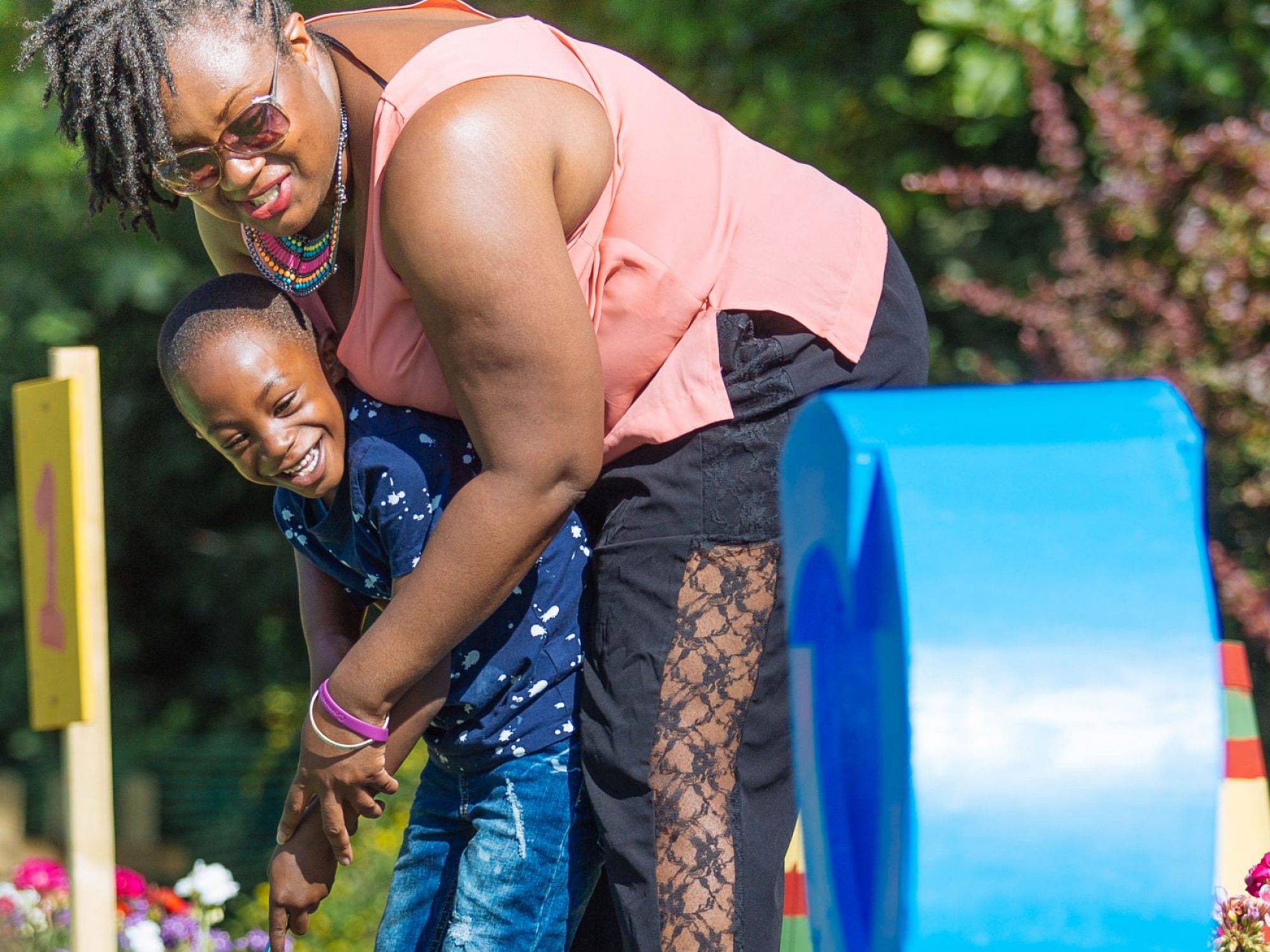 A woman helps a child putt a shot in golf