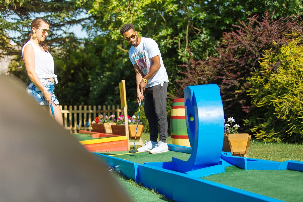A young man trying a looping hole in golf
