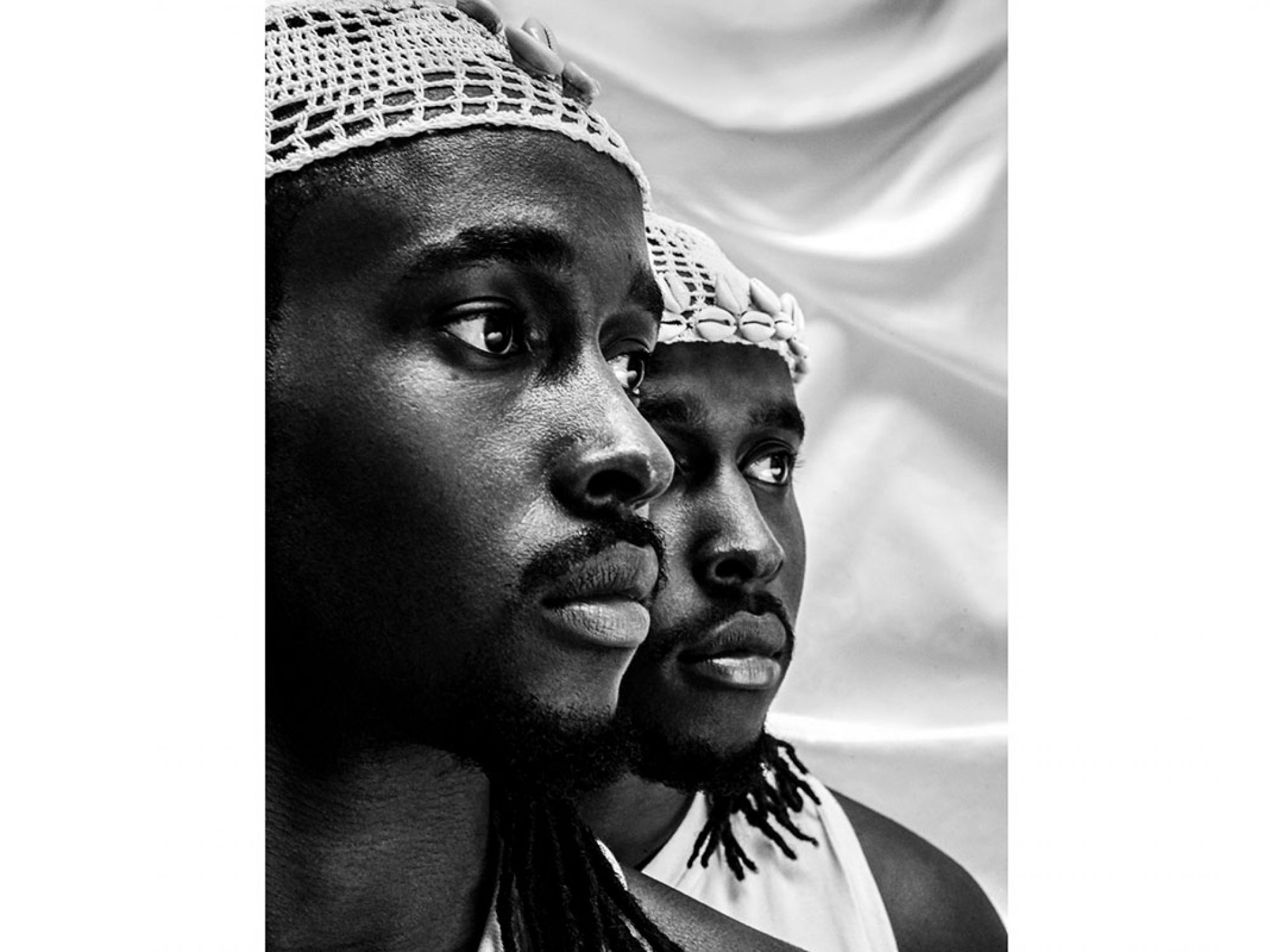 Black and white photo of two black men, faces half seen