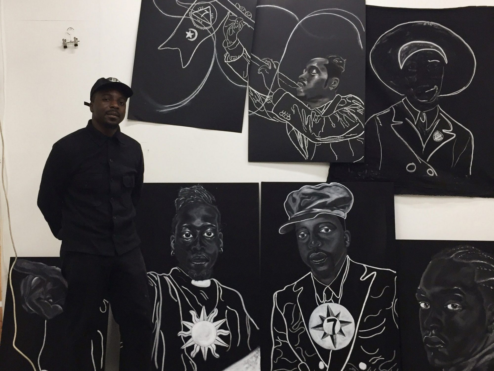 Hamed Maiye standing next to artwork