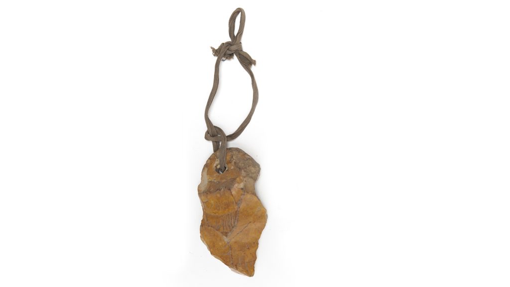 Jagged stone attached to looped string.