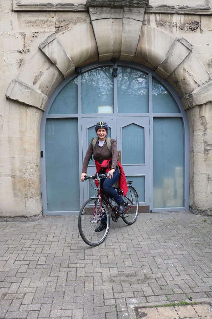 Carole sits on her bike in front of Horniman double doors