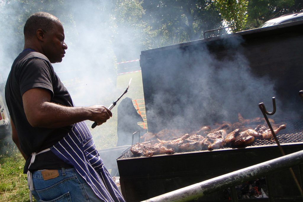 Chef cooking on a grill in the Gardens