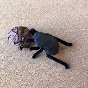 A dung beetle made out of pipe cleaners and tissue paper