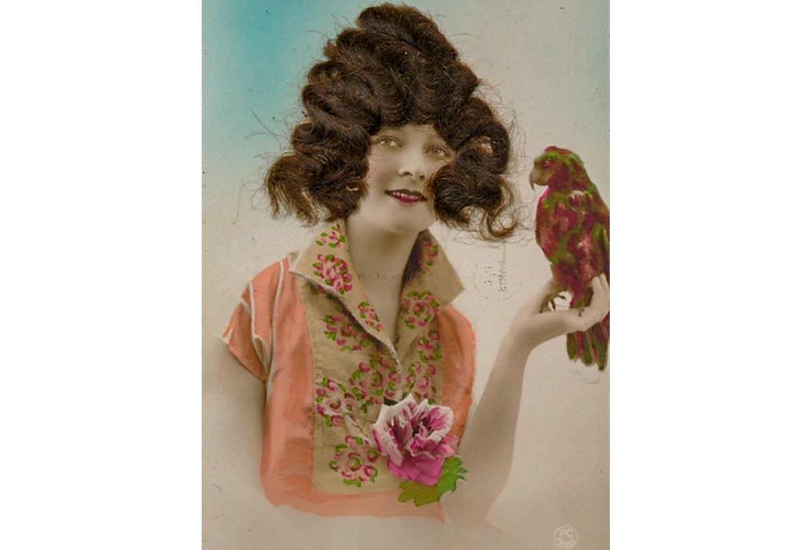 A postcard featuring an image of a woman with real hair stuck onto the card