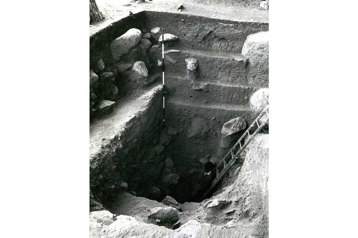 Excavation of a monument in Kenya. We can see steps and a ladder coming out of a hole in the ground