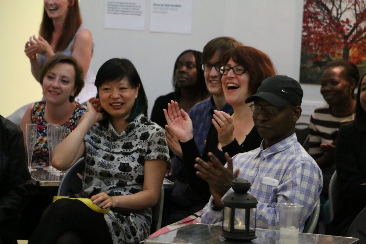 Audience members clap and smile as they watch a performance at the Horniman Museum